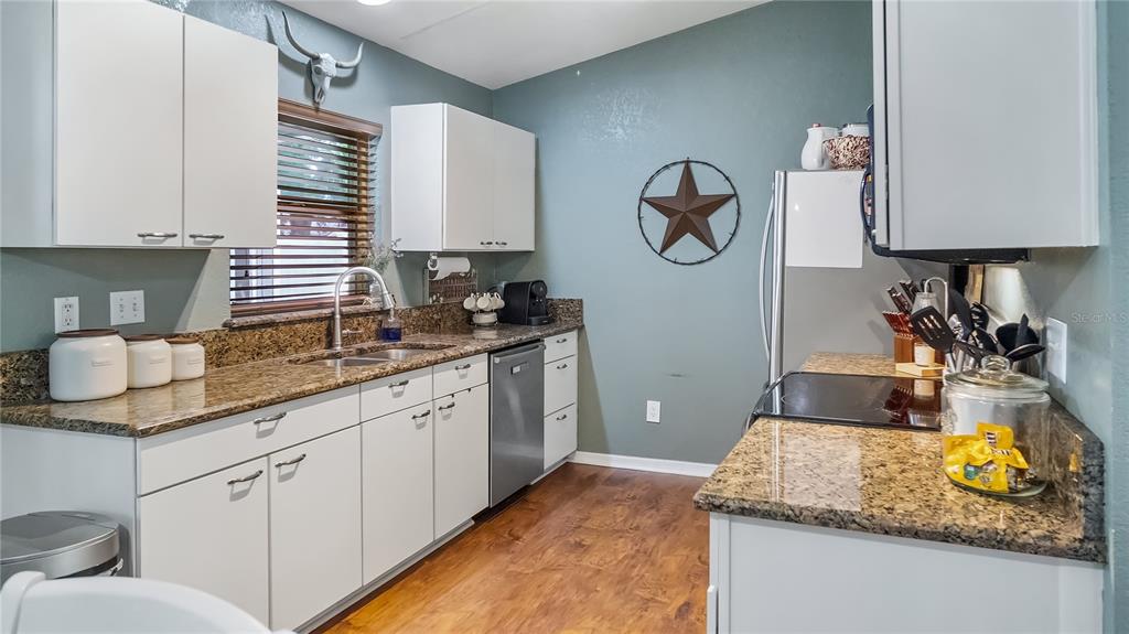 11746 Oswalt Road Clermont, FL 34711 - Photo 12 of 35 a kitchen with kitchen island granite countertop white cabinets and sink