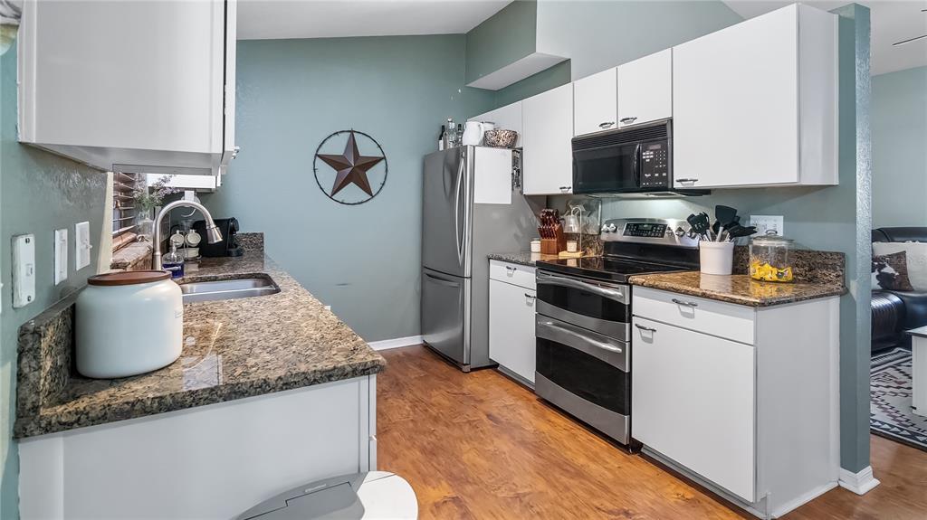 11746 Oswalt Road Clermont, FL 34711 - Photo 14 of 35 a kitchen with stainless steel appliances granite countertop a sink stove and refrigerator