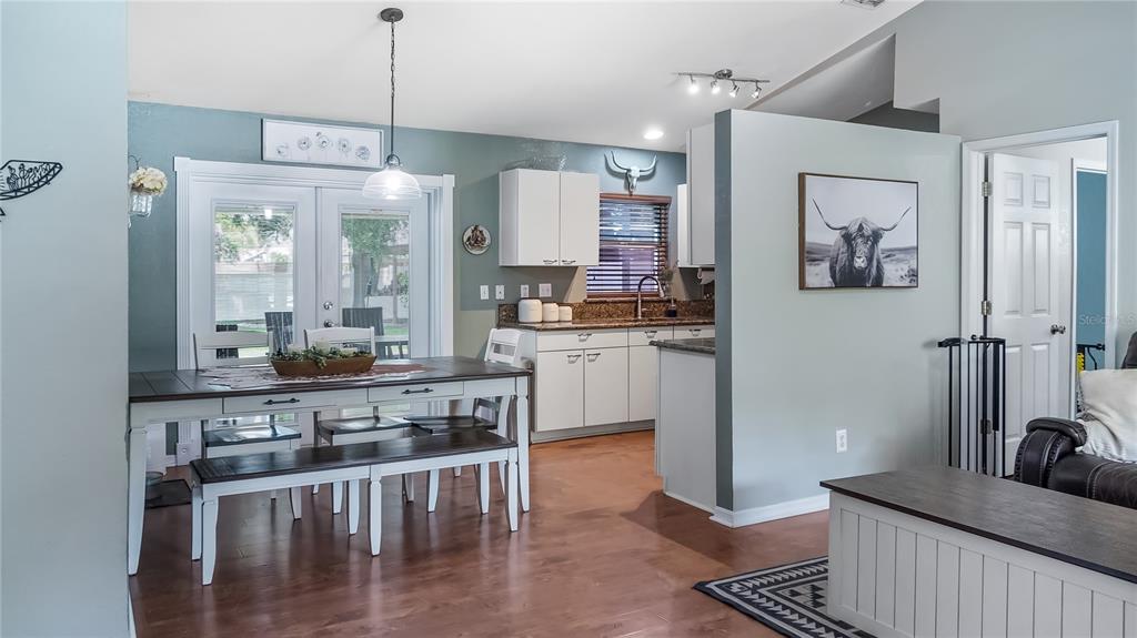 11746 Oswalt Road Clermont, FL 34711 - Photo 15 of 35 a kitchen with stainless steel appliances granite countertop a stove a sink dishwasher a refrigerator and white cabinets with wooden floor