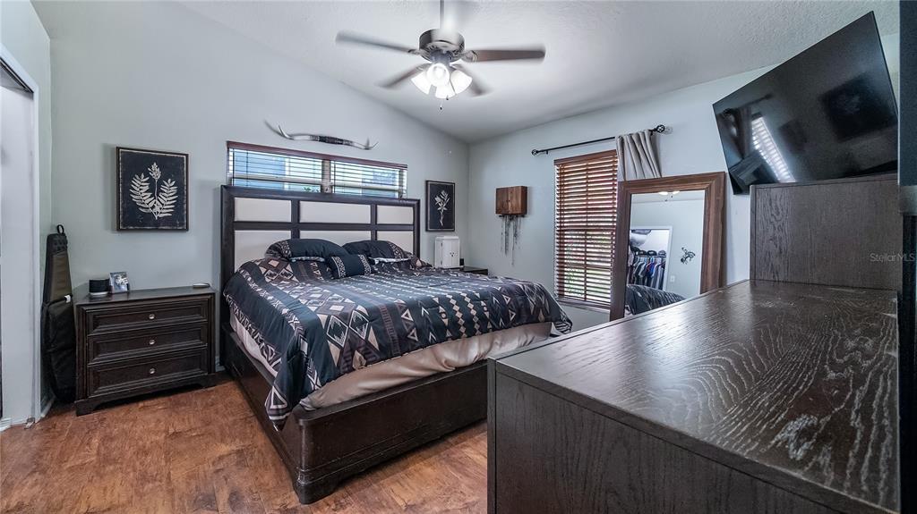 11746 Oswalt Road Clermont, FL 34711 - Photo 19 of 35 a bedroom with a bed and a flat tv screen on the dresser