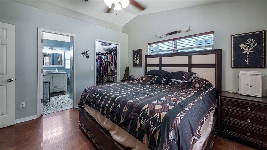 11746 Oswalt Road Clermont, FL 34711 - Photo 20 of 35 a bedroom with a bed and a chandelier