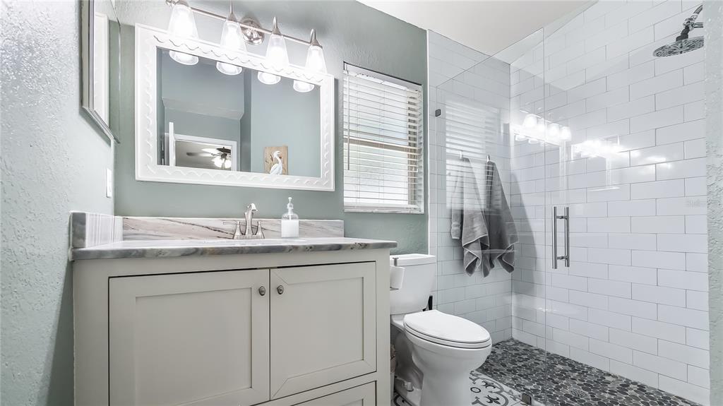 11746 Oswalt Road Clermont, FL 34711 - Photo 21 of 35 a bathroom with a granite countertop toilet sink and mirror