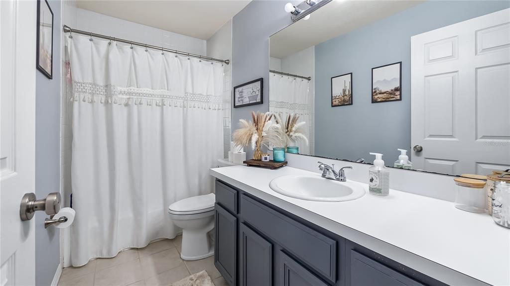 11746 Oswalt Road Clermont, FL 34711 - Photo 24 of 35 a bathroom with a sink a toilet and shower curtain