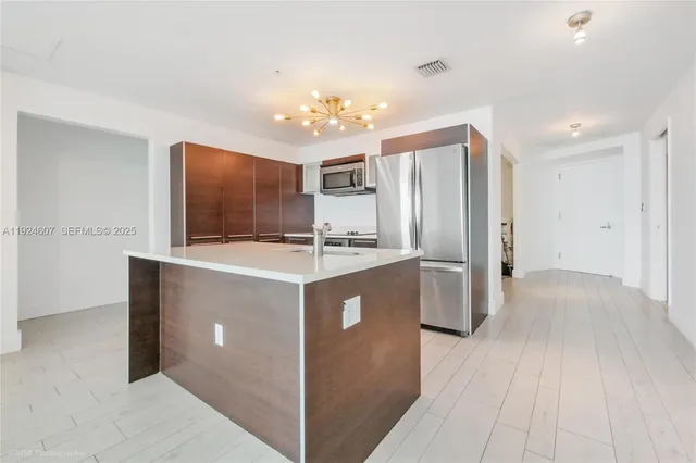 a kitchen with a refrigerator sink and cabinets
