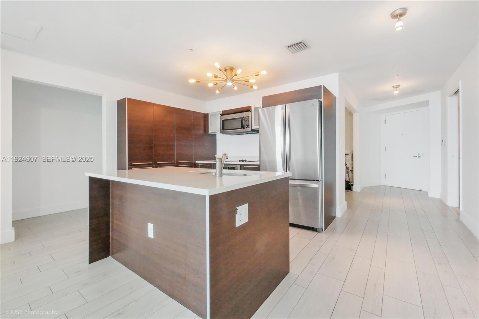 1900 North Bayshore Drive, Unit 2615 Miami, FL 33132 - Photo 5 of 17 a kitchen with a refrigerator sink and cabinets