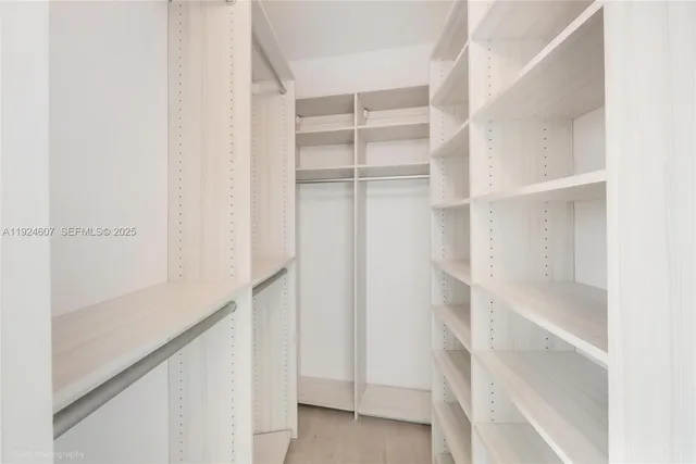 a view of walk in closet with empty racks