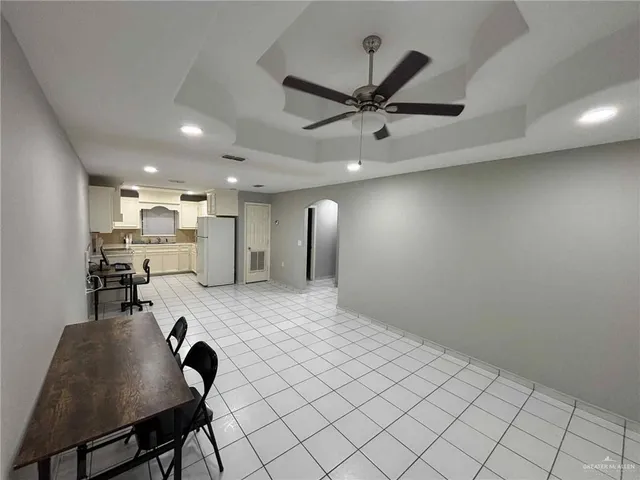 a living room with stainless steel appliances furniture a rug and a view of kitchen