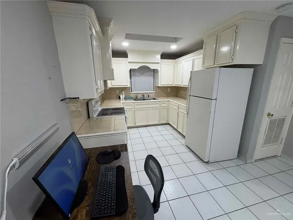 a kitchen with a refrigerator sink and cabinets