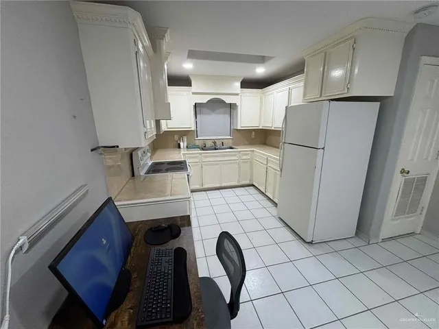 a kitchen with a refrigerator sink and cabinets