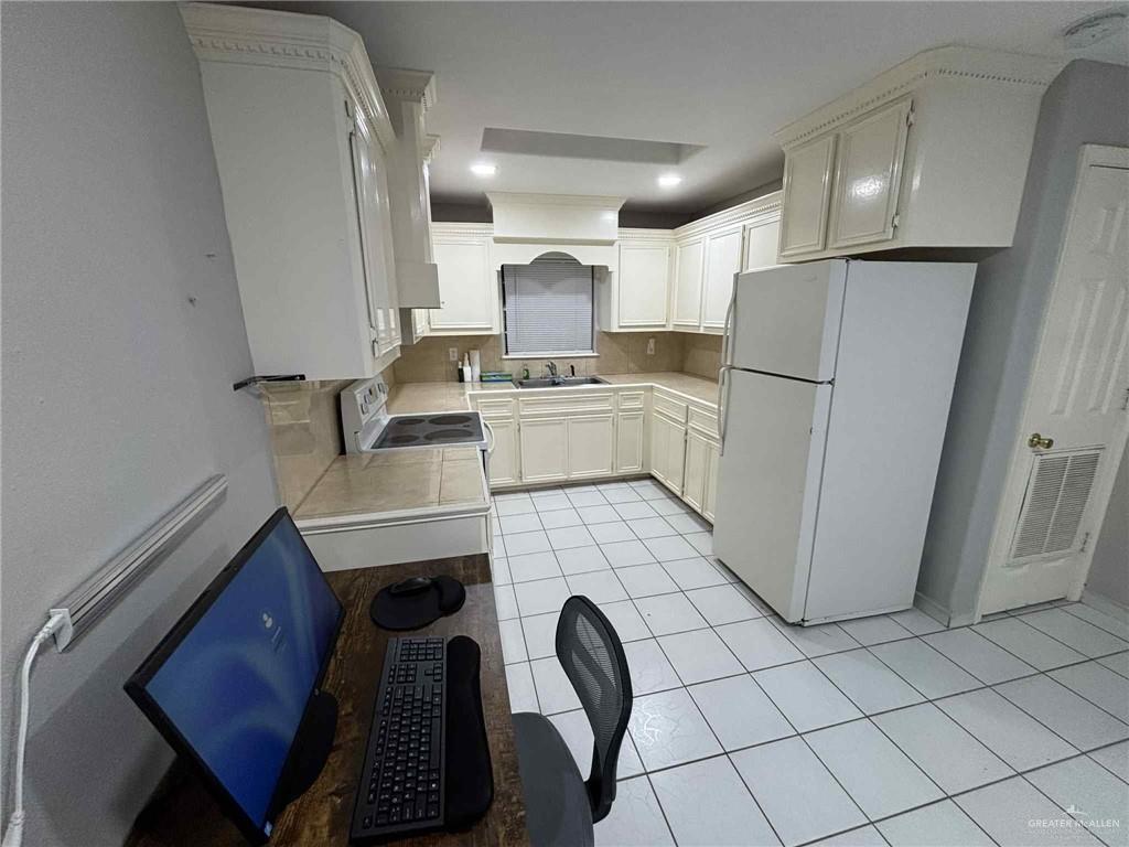 144 Redwood Road, Unit 2 Rio Grande City, TX 78582 - Photo 5 of 10 a kitchen with a refrigerator sink and cabinets