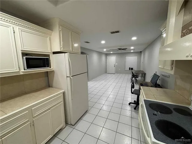 a kitchen with a refrigerator and a stove top oven