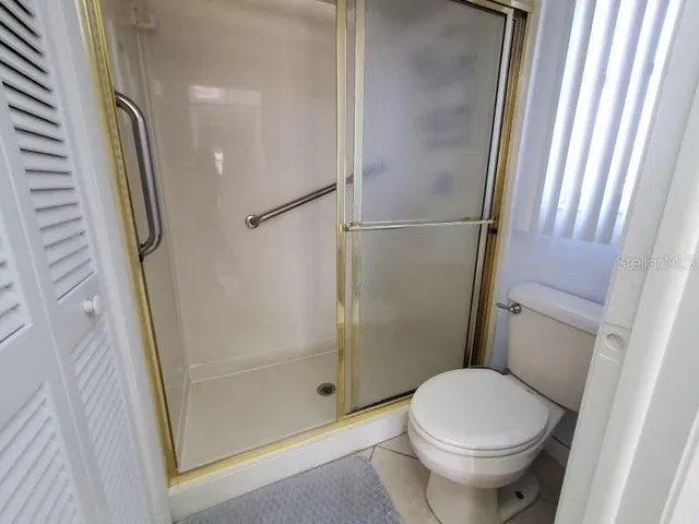 a bathroom with a glass door shower and toilet