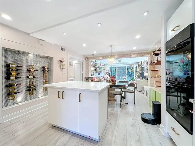 a large white kitchen with lots of counter space and stainless steel appliances