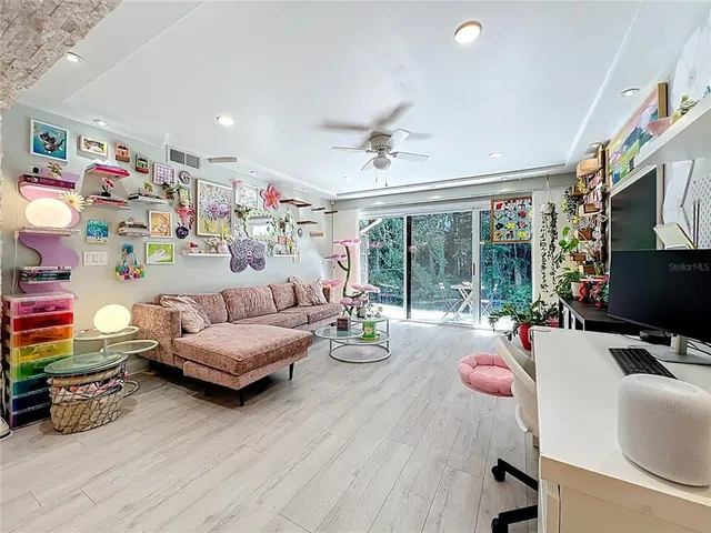 a bedroom with furniture a flat screen tv and a large window