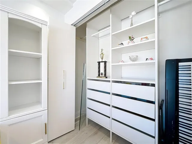 a view of walk in closet with empty racks