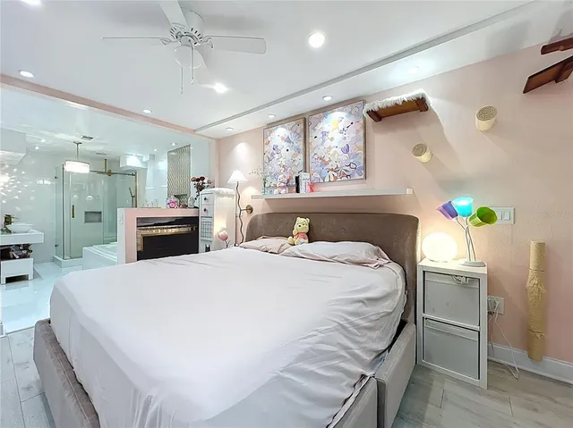 a large white bed in a bedroom next to a window