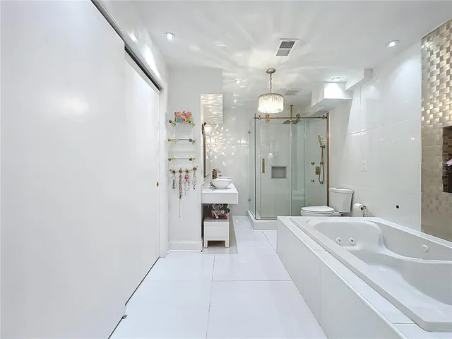 a bathroom with a bathtub a sink and a large mirror