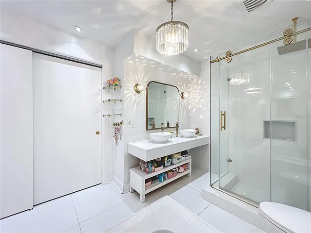 a bathroom with a double vanity sink mirror and shower