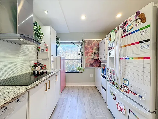 a kitchen with stainless steel appliances and wooden floor