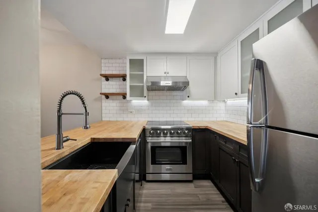 a kitchen with stainless steel appliances granite countertop a stove a sink and a refrigerator