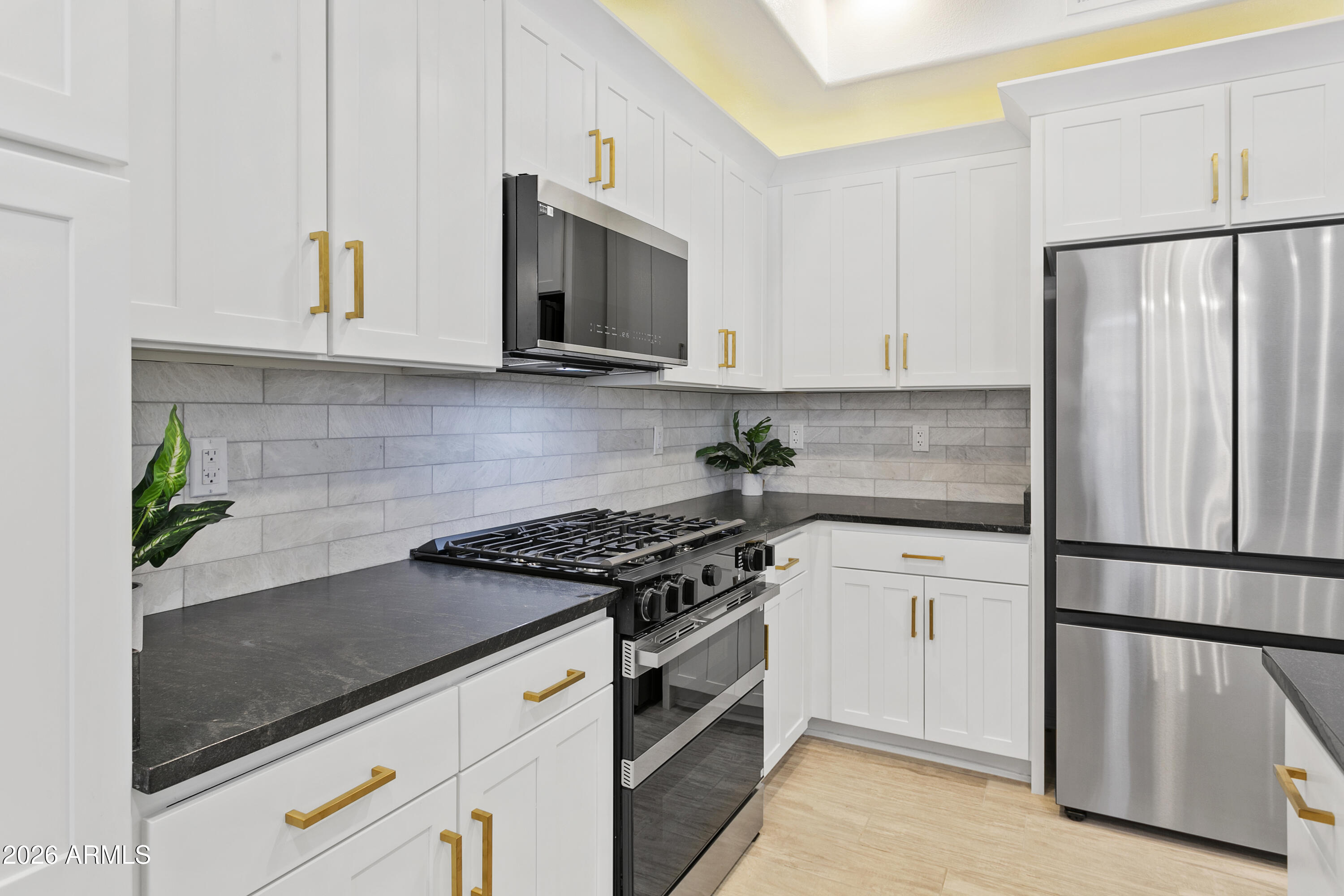 7601 East Indian Bend Road, Unit 1017 Scottsdale, AZ 85250 - Photo 3 of 49 a kitchen with granite countertop white cabinets and stainless steel appliances
