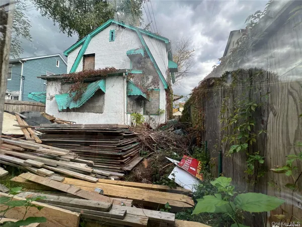 a view of a house with a small yard plants and large tree