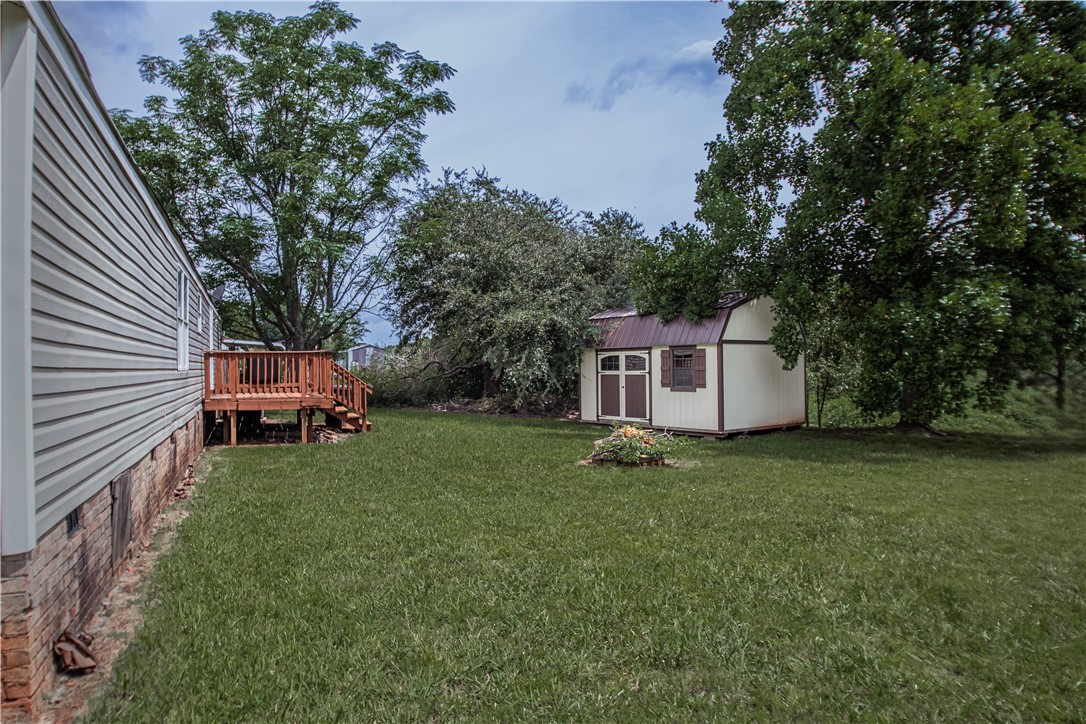169 West Bagwell Road Liberty, SC 29657 - Photo 4 of 29 A spacious yard provides ample room for activities, complemented by a sturdy shed and a wooden deck.