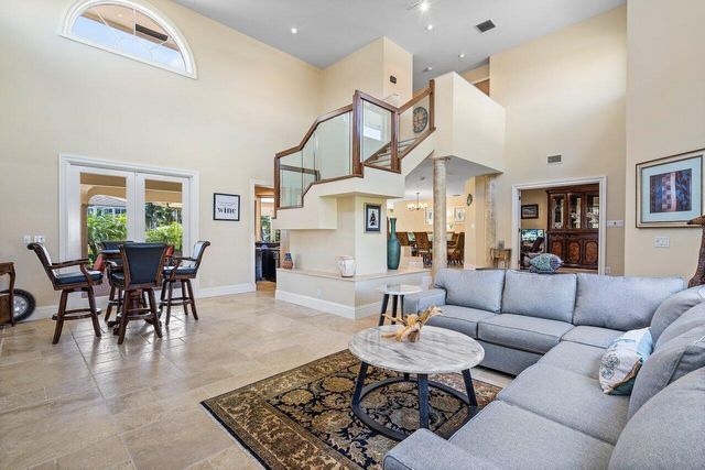 a living room with furniture kitchen view and a large window