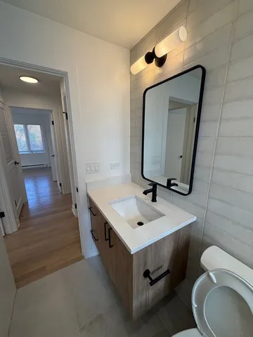 a bathroom with a toilet sink and mirror