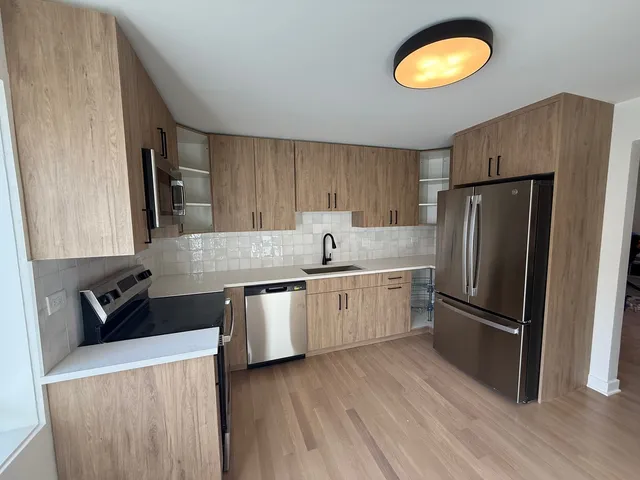 a kitchen with granite countertop a refrigerator stove top oven and sink