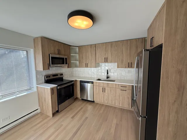 a kitchen with granite countertop a refrigerator stove top oven and sink