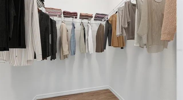 a view of walk in closet with clothes