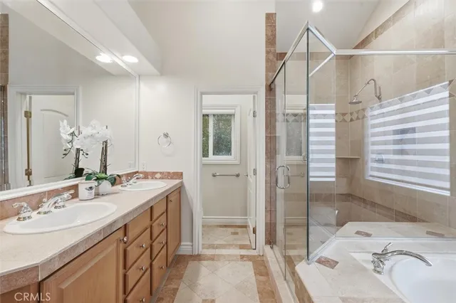 a bathroom with a sink and mirror with bathtub