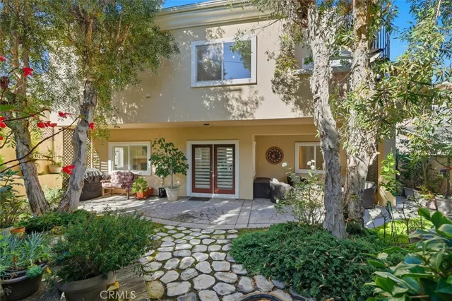 a view of a brick house with a large windows and a table and chairs