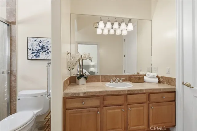 a bathroom with a granite countertop sink a toilet and a mirror