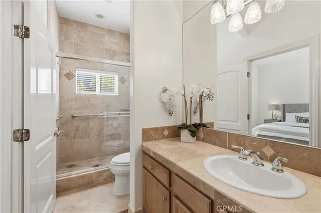 a bathroom with a granite countertop sink a toilet and shower