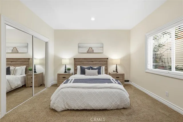 a spacious bedroom with a bed and glass window