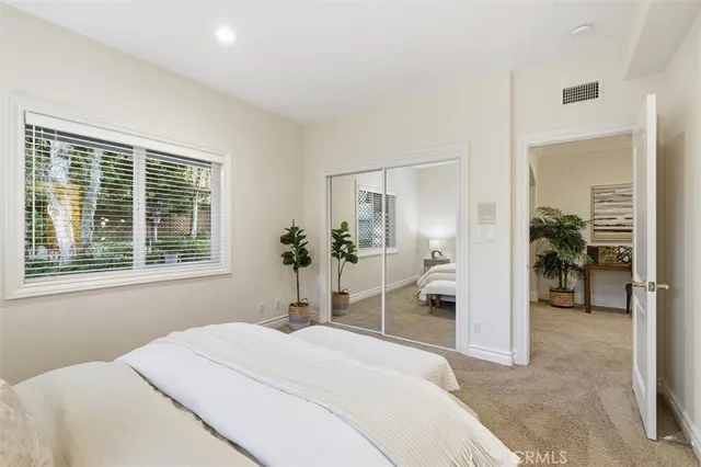 a bedroom with a bed and a large window