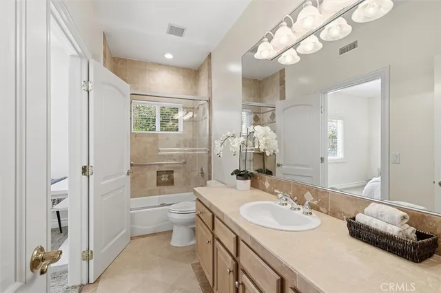 a bathroom with a granite countertop sink a toilet and a mirror