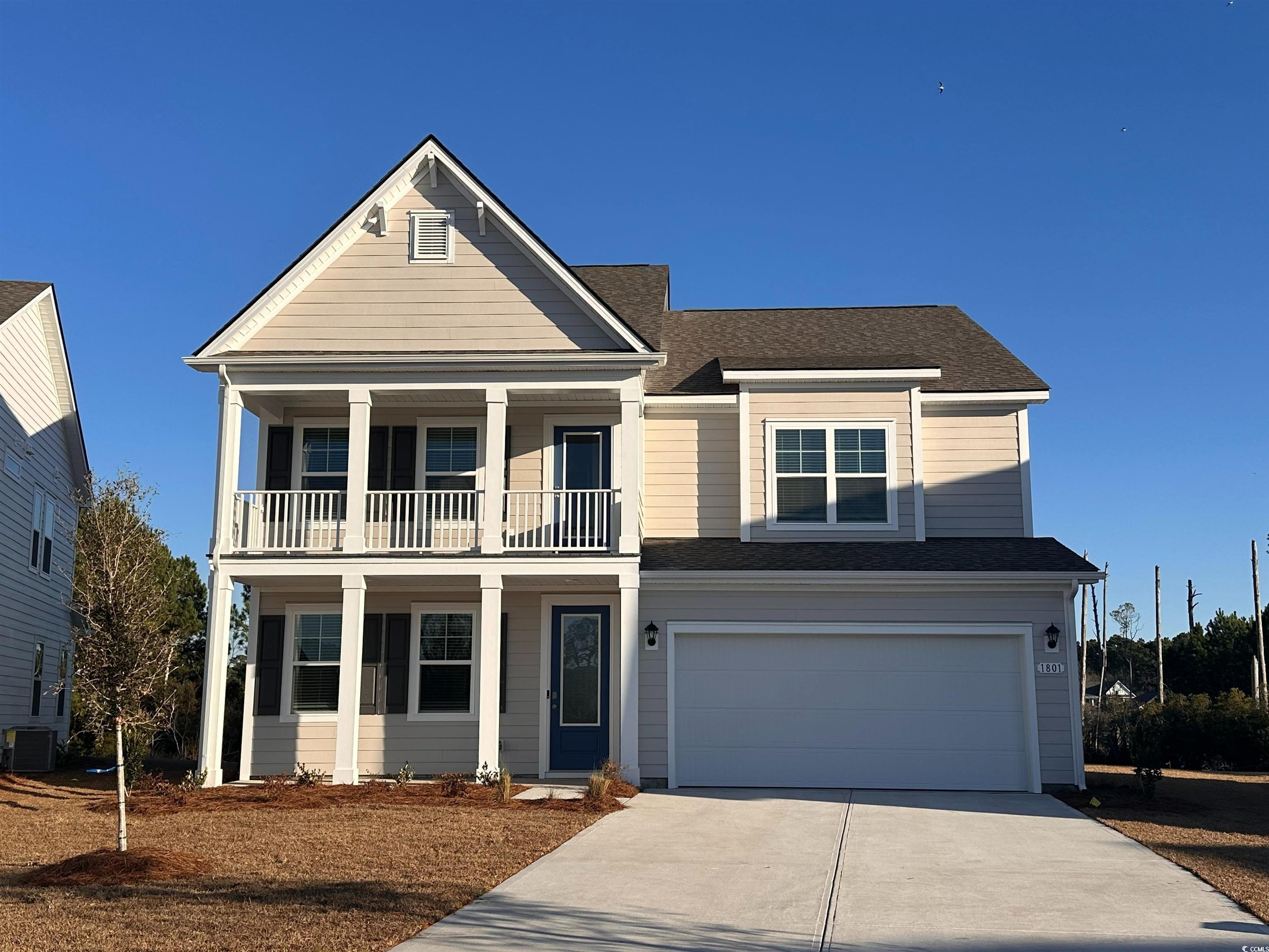 View of front facade with a balcony, a garage, and