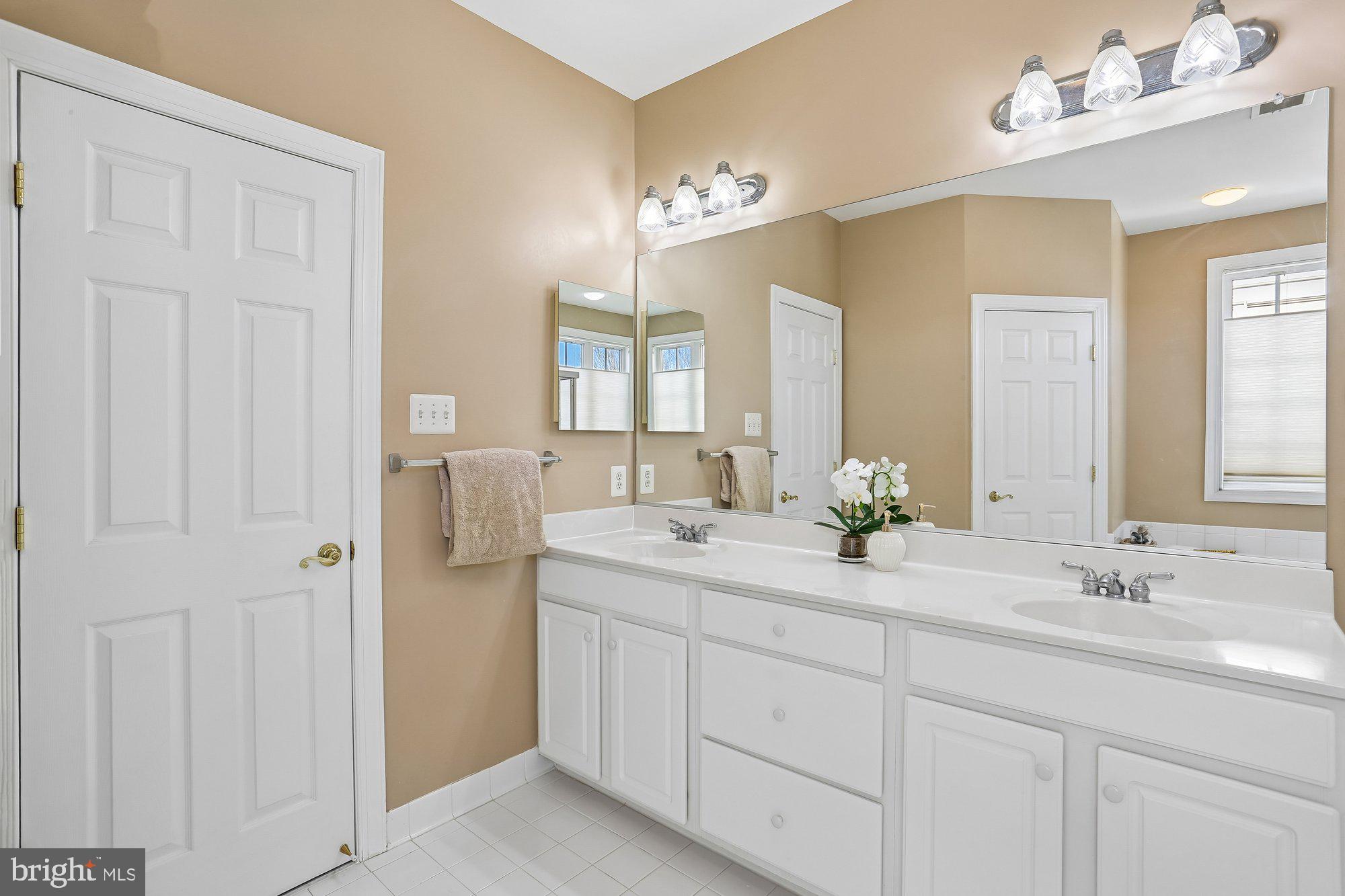 945 Main Street Gaithersburg, MD 20878 - Photo 29 of 57 a bathroom with a double vanity sink and a mirror