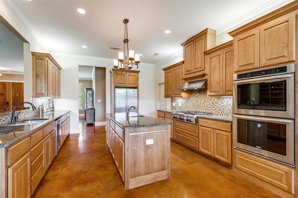 643 County Road 2255 Telephone, TX 75488 - Photo 13 of 40 Kitchen featuring tasteful backsplash, appliances with stainless steel finishes, concrete floors, ornamental molding, and dark stone counters