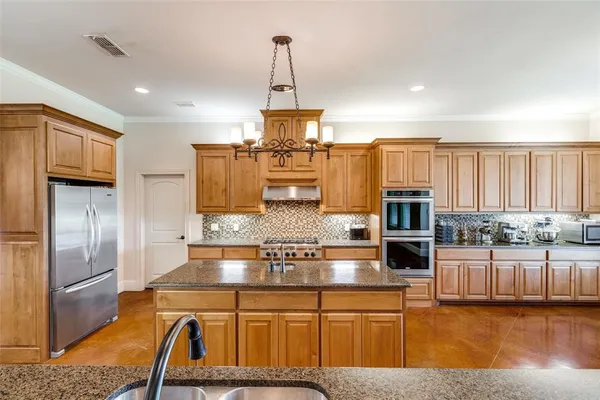 a kitchen with stainless steel appliances granite countertop a sink refrigerator and microwave