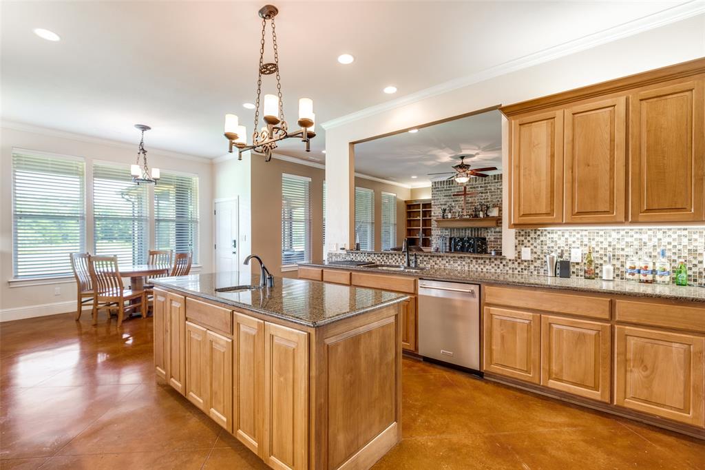 643 County Road 2255 Telephone, TX 75488 - Photo 15 of 40 Kitchen with dark stone countertops, crown molding, tasteful backsplash, decorative light fixtures, and healthy amount of natural light