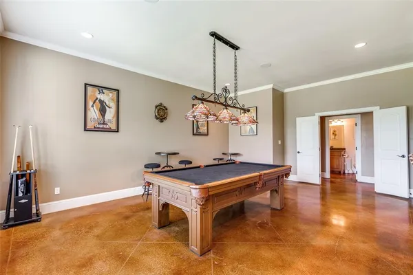 a living room with pool table and a chandelier