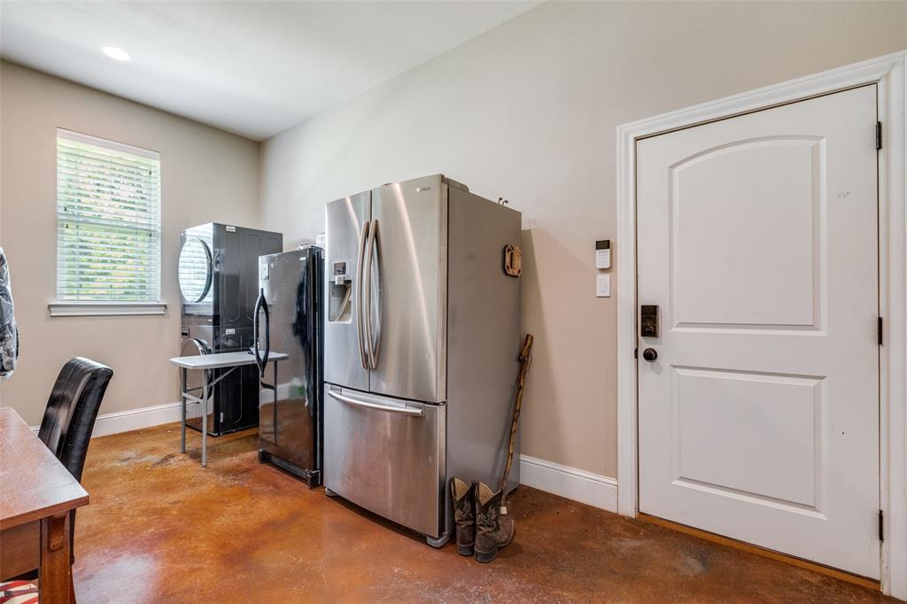 643 County Road 2255 Telephone, TX 75488 - Photo 35 of 40 Kitchen featuring stainless steel fridge, concrete flooring, freestanding refrigerator, and estacked washer and dryer