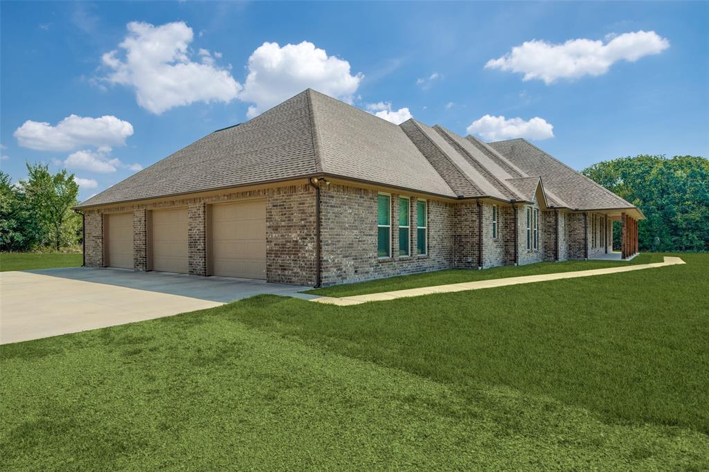 643 County Road 2255 Telephone, TX 75488 - Photo 37 of 40 View of front of house featuring a shingled roof, brick siding, a front lawn, and driveway