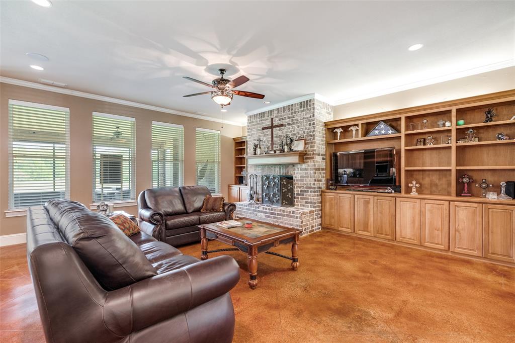 643 County Road 2255 Telephone, TX 75488 - Photo 8 of 40 Living room featuring a brick fireplace, ornamental molding, a ceiling fan, recessed lighting, and built in features