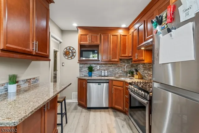 a kitchen with stainless steel appliances granite countertop a stove a sink and a microwave
