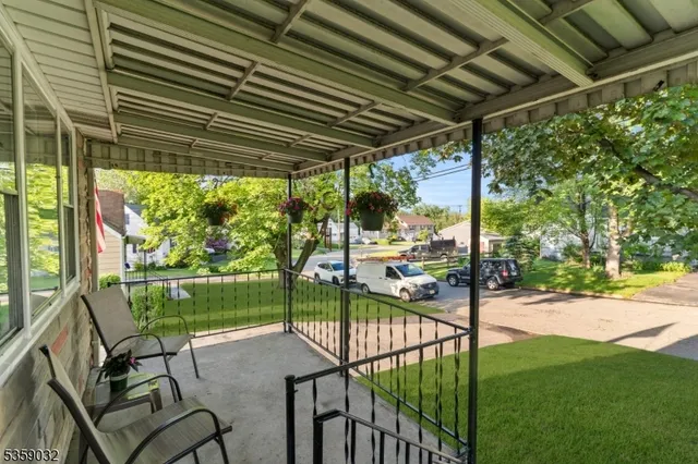 a view of a backyard with table and chairs under an umbrella with a small yard